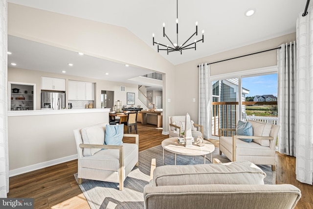 living room with hardwood / wood-style flooring, vaulted ceiling, and a chandelier