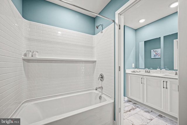 bathroom featuring tiled shower / bath and vanity