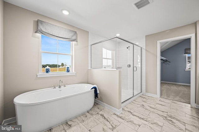 bathroom featuring shower with separate bathtub