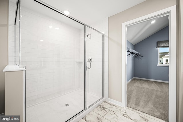 bathroom with a shower with door and vaulted ceiling