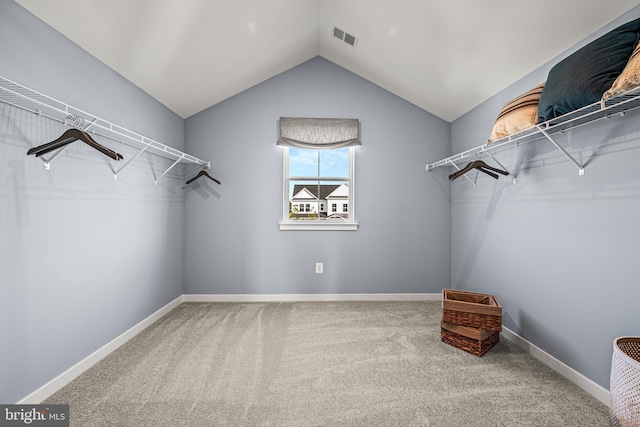 walk in closet with carpet and lofted ceiling