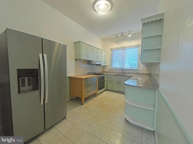 kitchen featuring light stone counters, appliances with stainless steel finishes, sink, and decorative backsplash