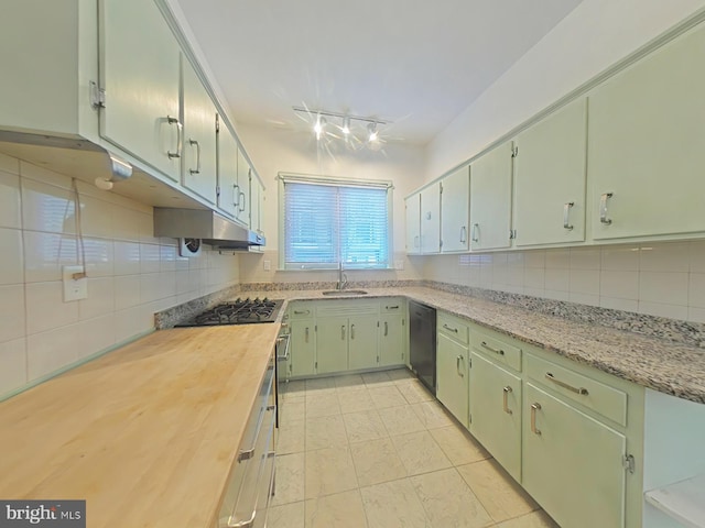 kitchen with light tile patterned flooring, stainless steel gas stovetop, dishwasher, sink, and decorative backsplash