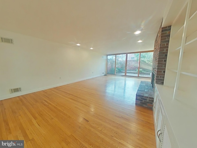 unfurnished room with expansive windows and light wood-type flooring