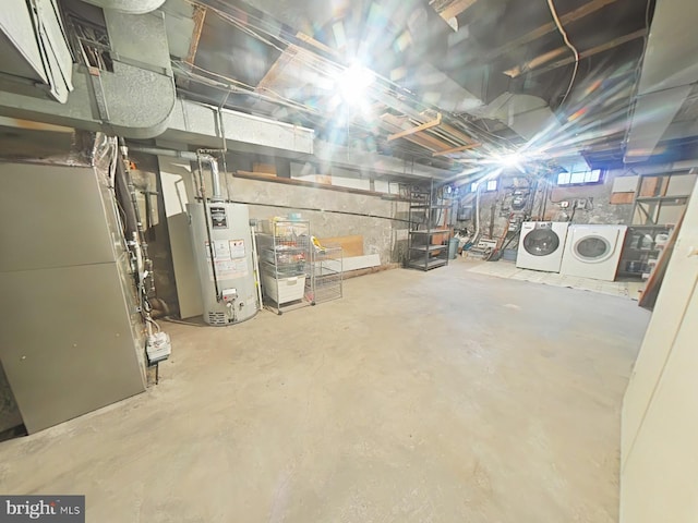 basement featuring heating unit, gas water heater, and independent washer and dryer