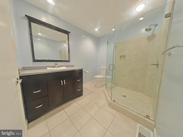 bathroom with tile patterned flooring, vanity, a shower with door, and toilet