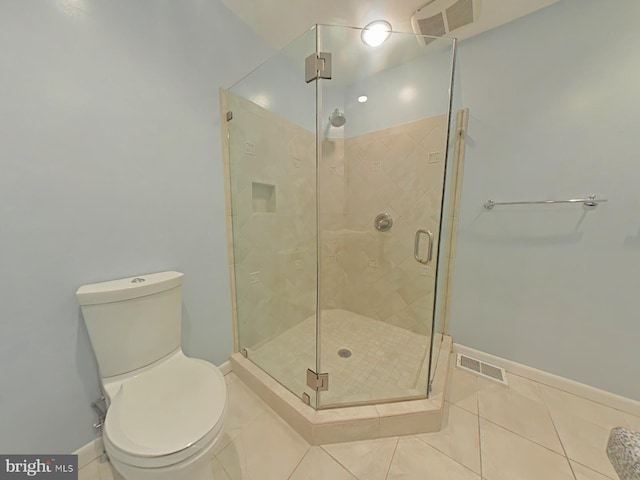 bathroom with tile patterned floors, toilet, and a shower with shower door