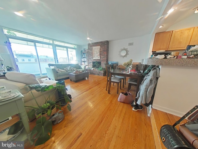 living room with a fireplace and light wood-type flooring