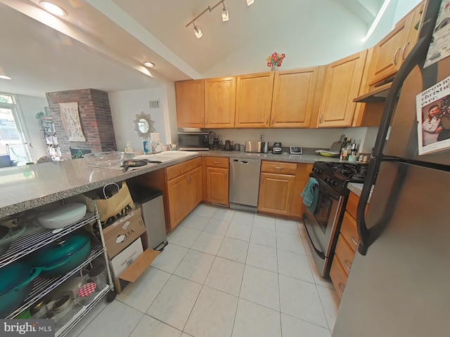 kitchen featuring vaulted ceiling, light tile patterned floors, stainless steel appliances, light stone countertops, and track lighting