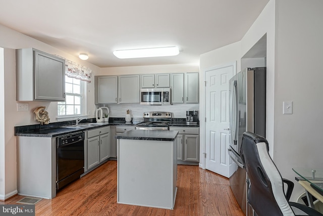 kitchen featuring sink, gray cabinets, appliances with stainless steel finishes, and a kitchen island