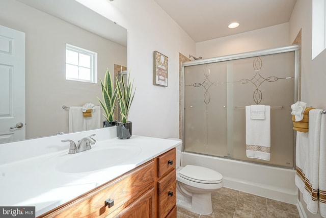 full bathroom featuring shower / bath combination with glass door, tile patterned floors, vanity, and toilet