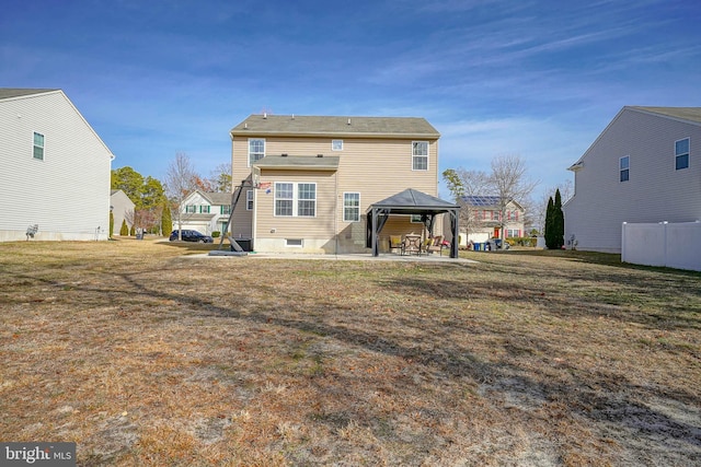 back of property featuring a gazebo and a lawn