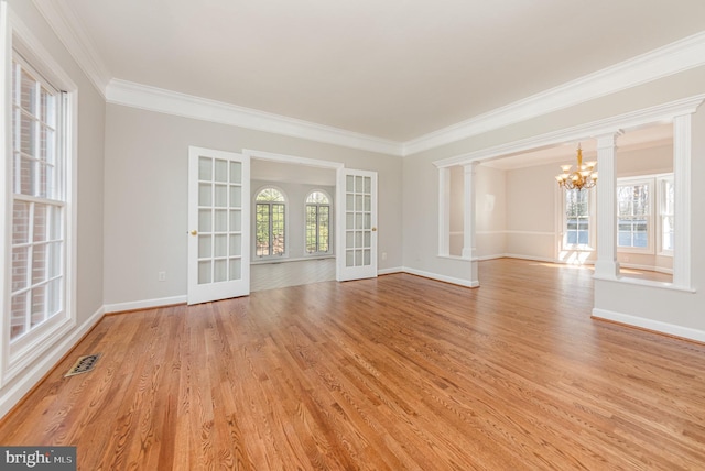 unfurnished room featuring visible vents, plenty of natural light, and ornate columns