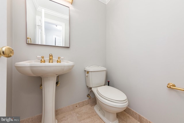 half bathroom with toilet, baseboards, and tile patterned floors