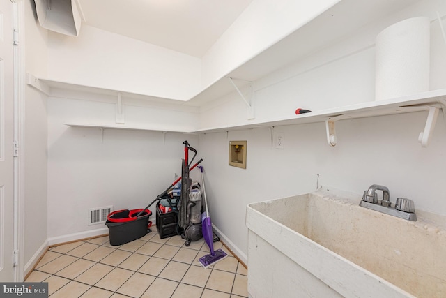 clothes washing area with washer hookup, visible vents, a sink, laundry area, and baseboards