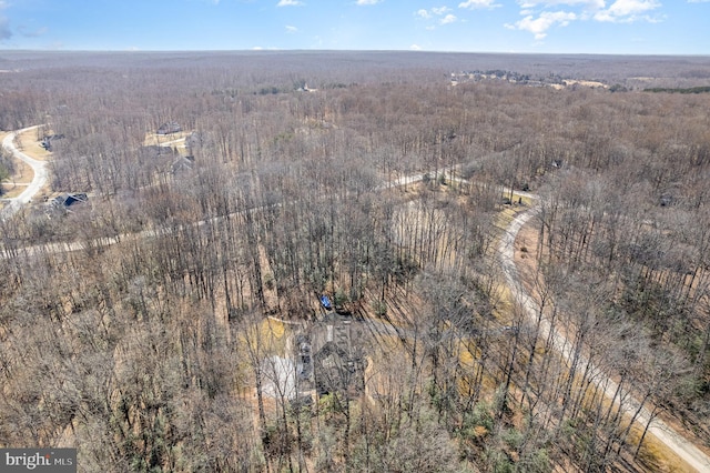 drone / aerial view featuring a wooded view