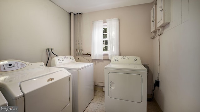 laundry area with cabinets, light tile patterned floors, and independent washer and dryer