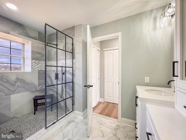 bathroom featuring tiled shower and vanity