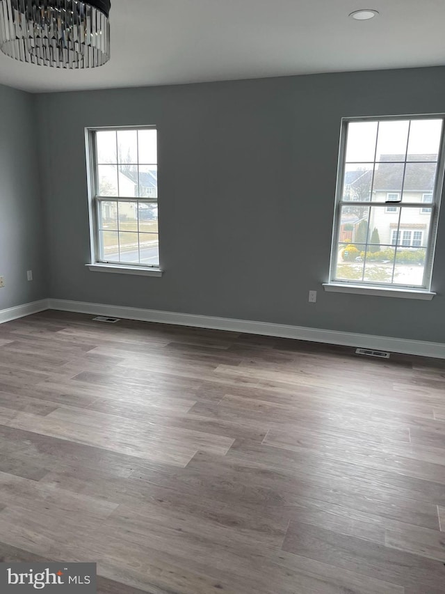 unfurnished room with hardwood / wood-style flooring and a wealth of natural light