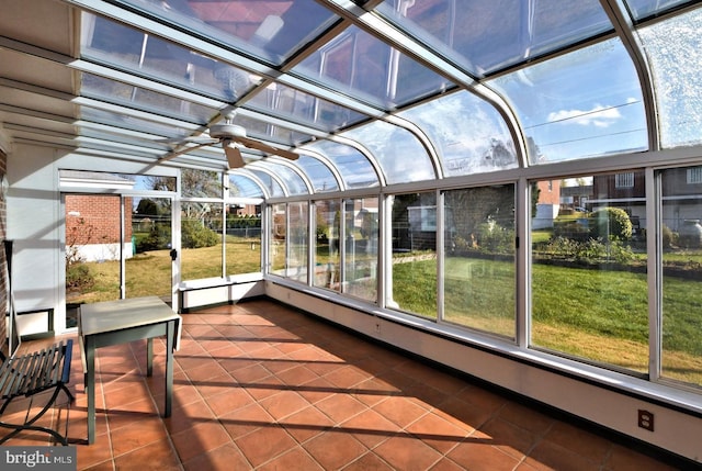 unfurnished sunroom featuring ceiling fan