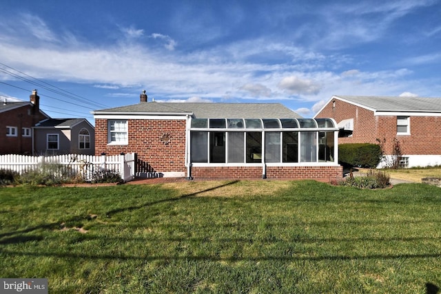 back of house with a yard and a sunroom