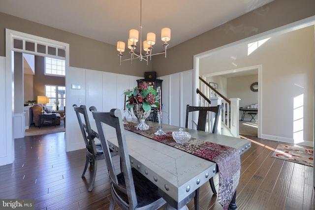 dining room with stairway, dark wood-style floors, and a notable chandelier
