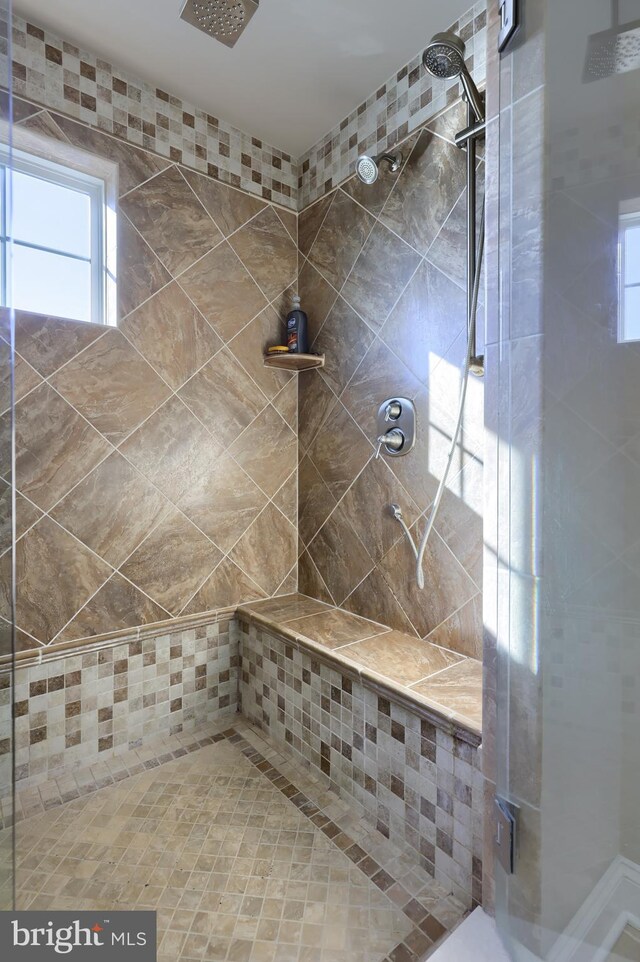 bathroom featuring plenty of natural light and tiled shower