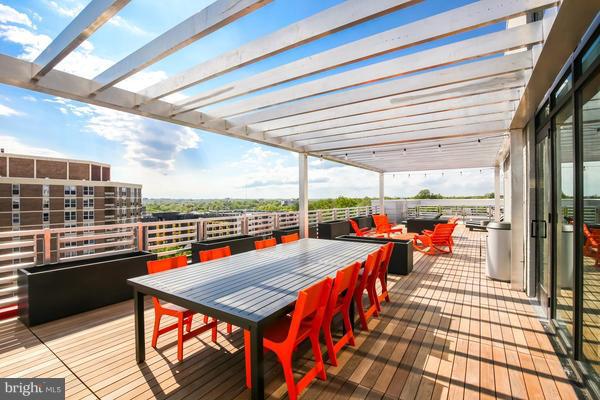 wooden terrace with a fire pit and a pergola