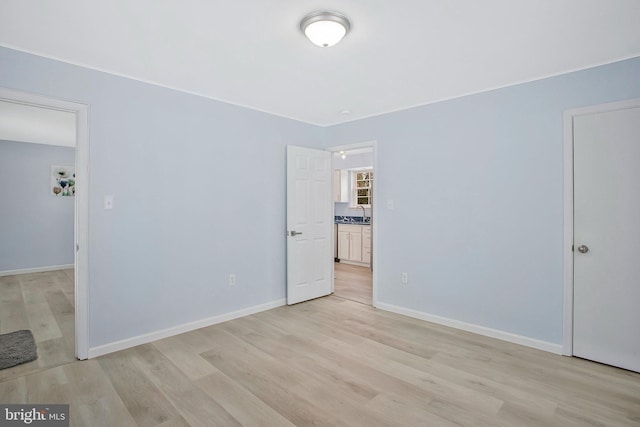 unfurnished bedroom with sink and light hardwood / wood-style flooring