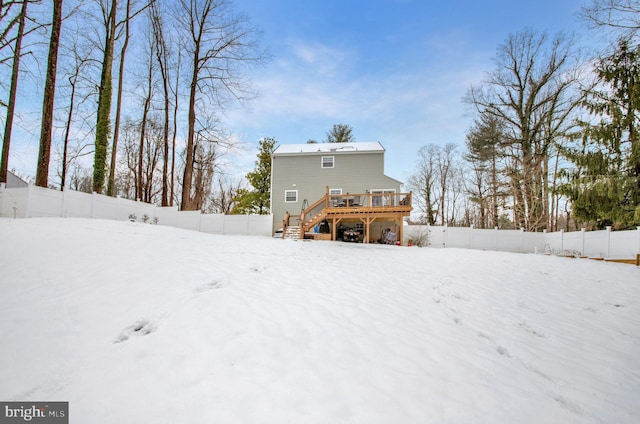 snow covered house with a wooden deck