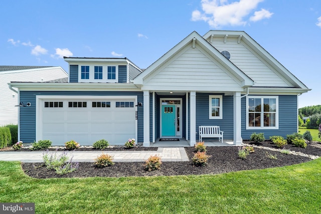 view of front of property featuring a garage, covered porch, and a front yard