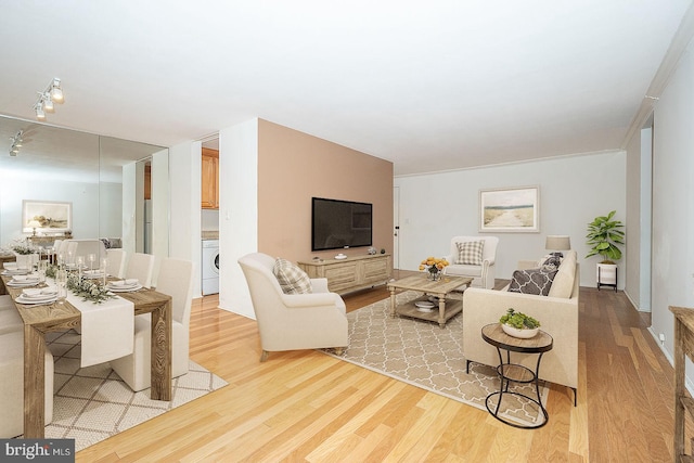 living room with washer / clothes dryer and light wood-type flooring