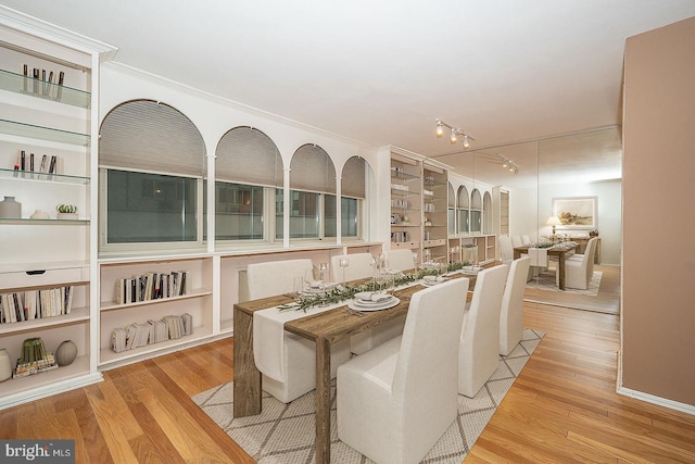 dining room with track lighting and light hardwood / wood-style flooring