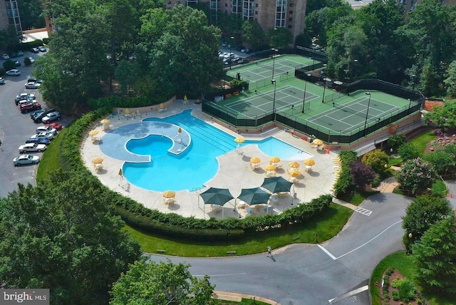 view of swimming pool featuring a tennis court