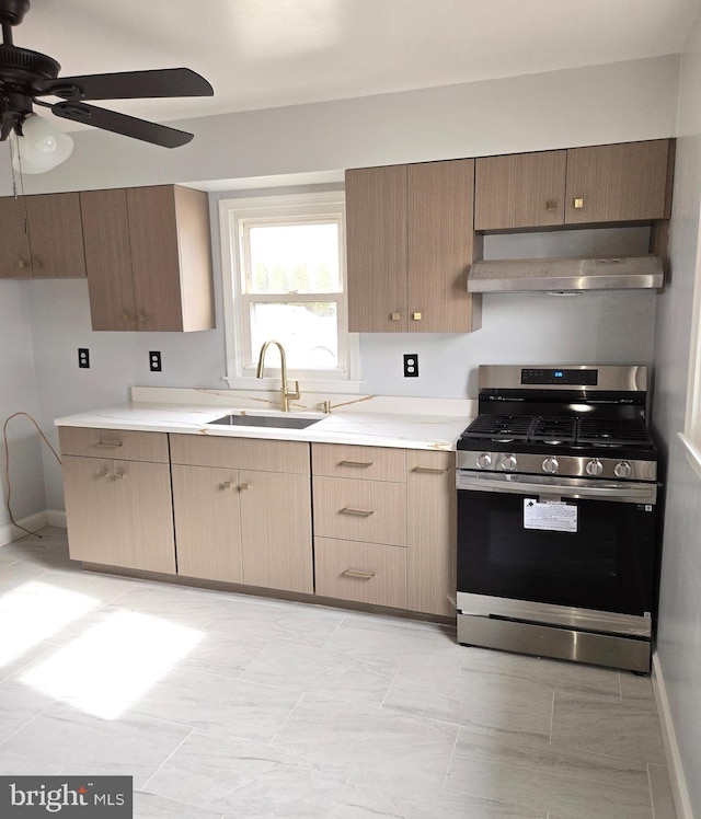 kitchen with sink, gas stove, and ceiling fan