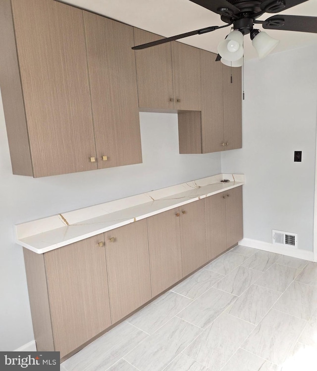 kitchen featuring light brown cabinetry and ceiling fan