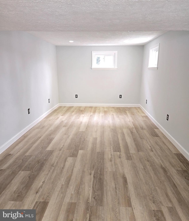 basement with a textured ceiling and light wood-type flooring