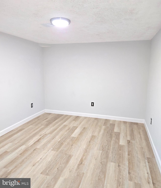 empty room featuring light hardwood / wood-style floors and a textured ceiling