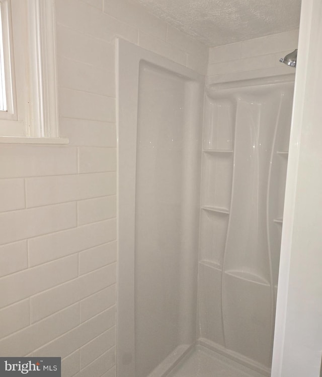 bathroom with curtained shower and a textured ceiling