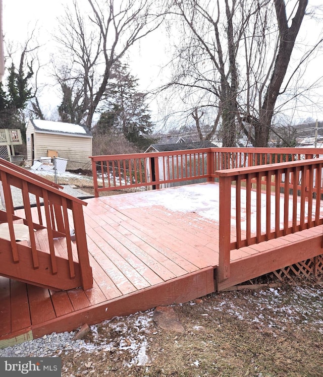 snow covered deck featuring a shed