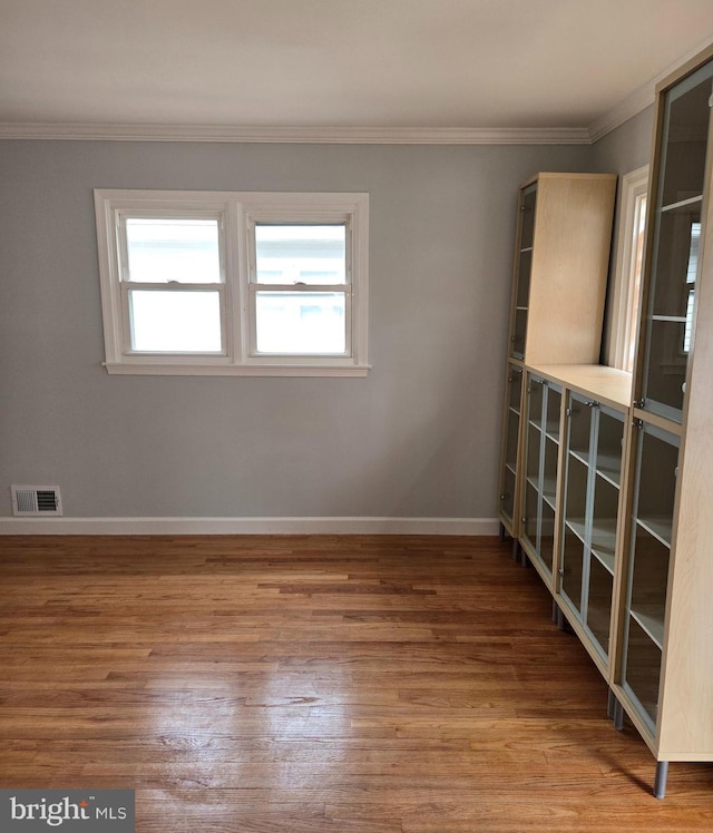 unfurnished room with hardwood / wood-style flooring and ornamental molding