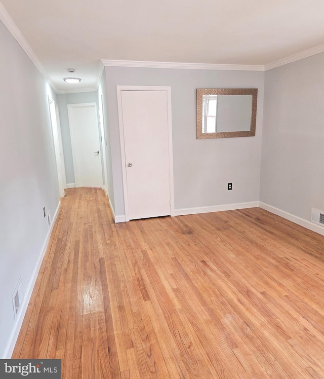 spare room featuring ornamental molding and light hardwood / wood-style floors