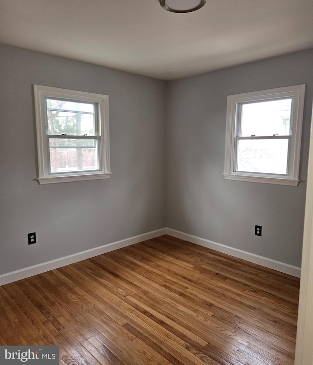 spare room featuring hardwood / wood-style flooring and a wealth of natural light