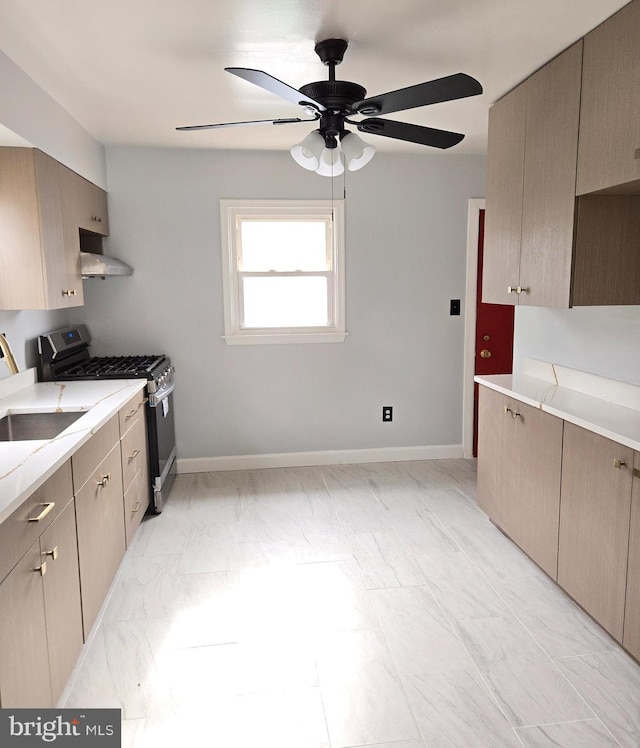 kitchen featuring wall chimney range hood, sink, ceiling fan, gas stove, and light brown cabinetry