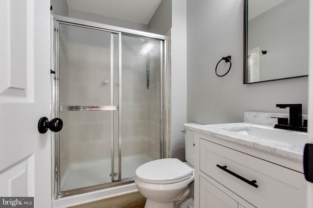 full bath featuring a shower stall, toilet, vanity, and wood finished floors