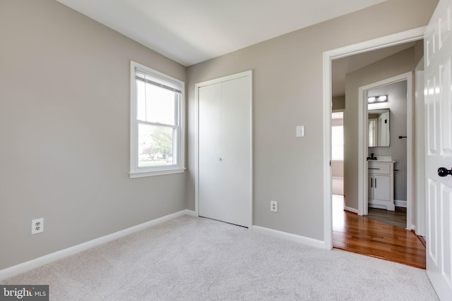 unfurnished bedroom with baseboards, carpet floors, and a closet