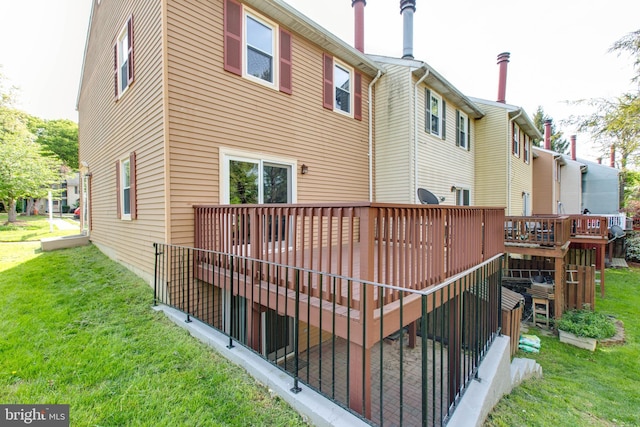 back of property with a lawn and a deck