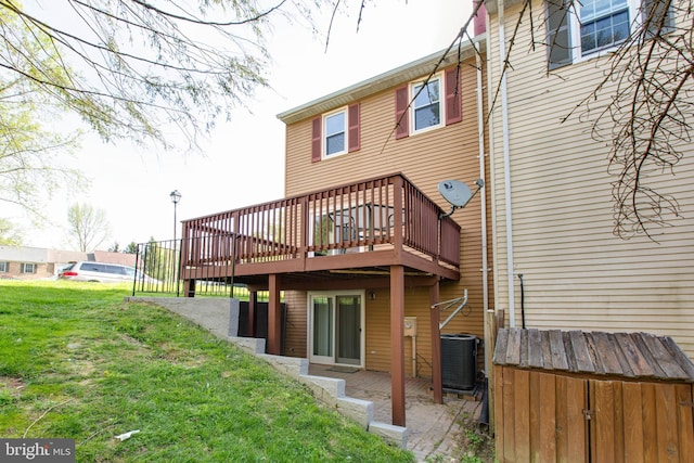 back of property featuring central air condition unit, a lawn, and a deck