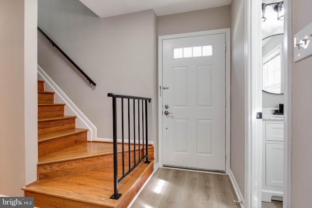 foyer with light wood-type flooring and stairway