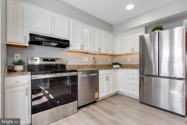 kitchen featuring stainless steel appliances, light wood-style floors, white cabinetry, light stone countertops, and under cabinet range hood
